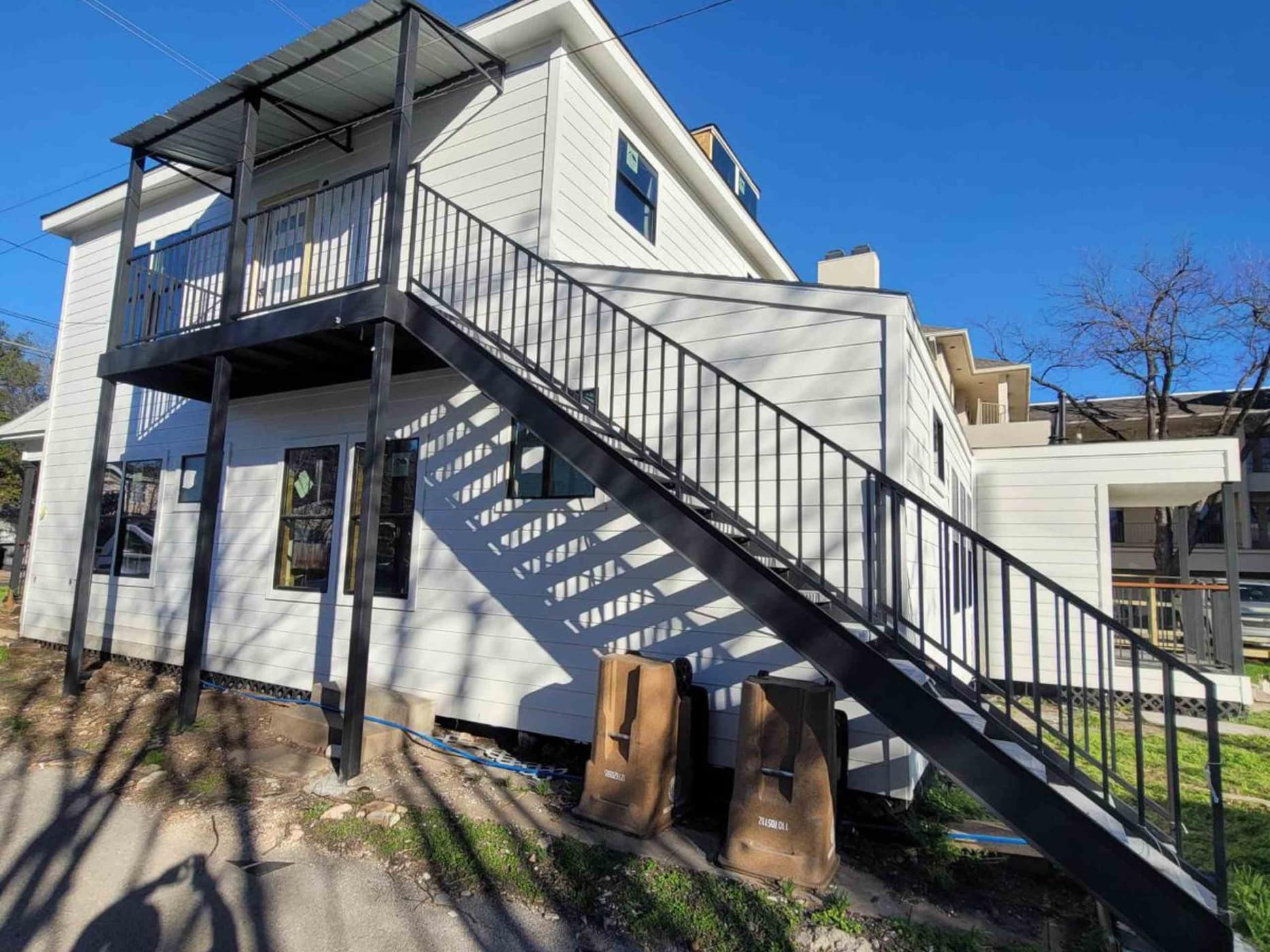Custom exterior steel staircase and balcony railing built by Eleven Steel & Wood Services in Houston